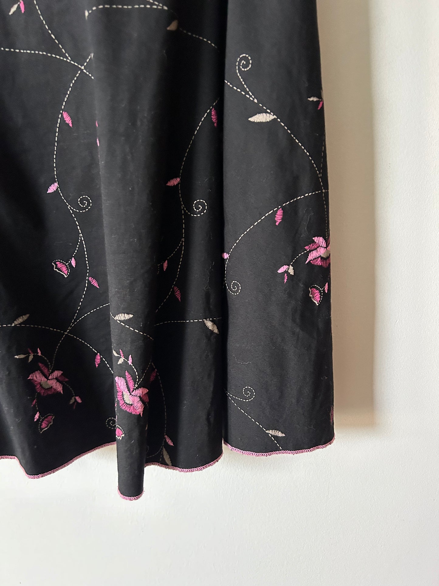 black skirt with embroidered pink floral details