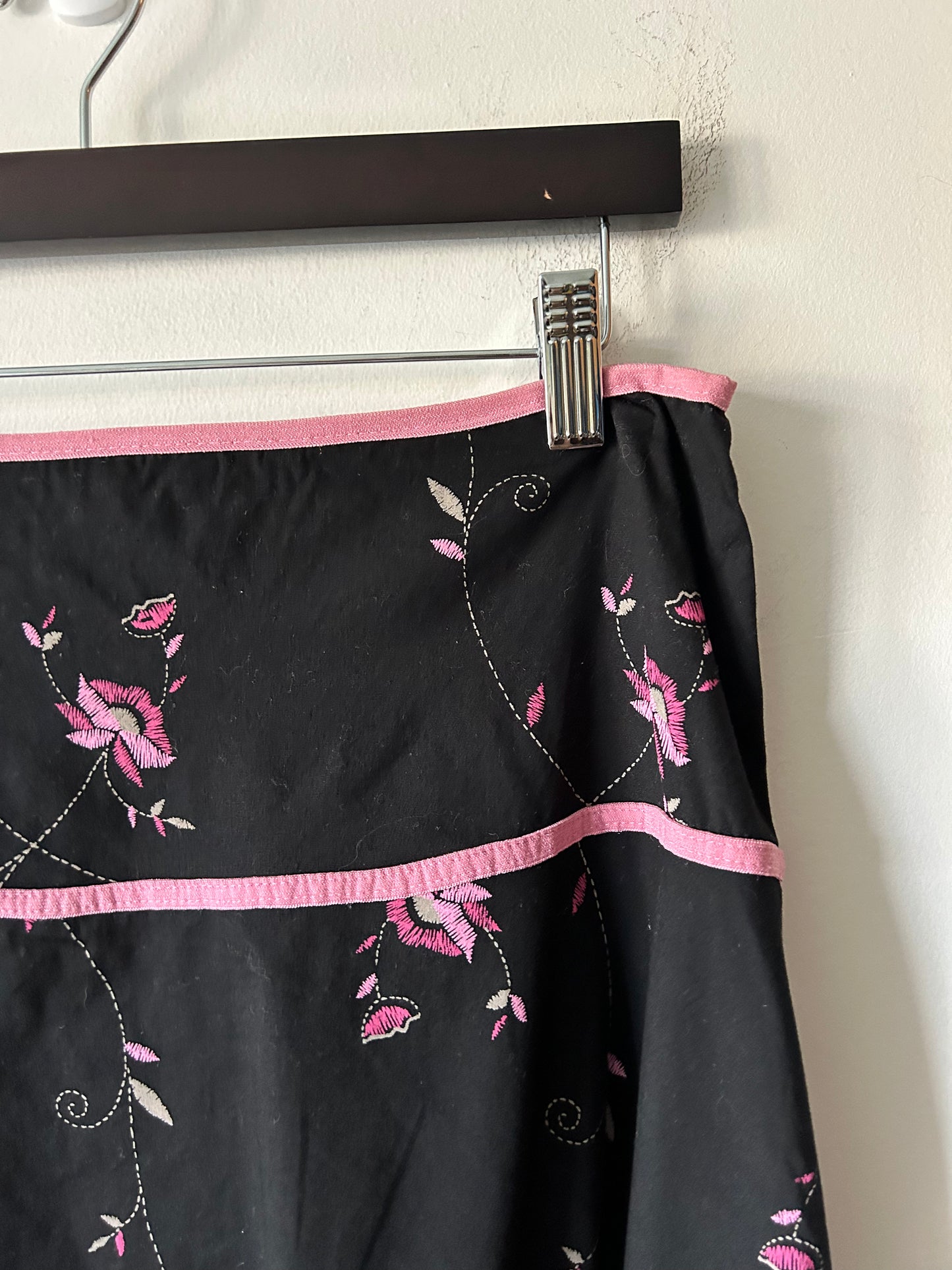 black skirt with embroidered pink floral details