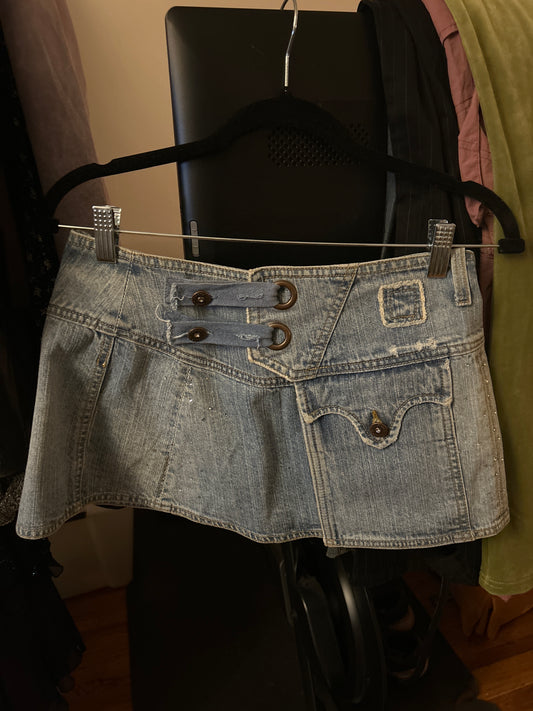 Pink jeans piled on a mini skirt with grommets