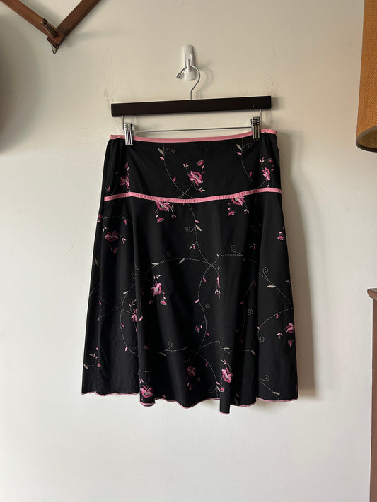 black skirt with embroidered pink floral details